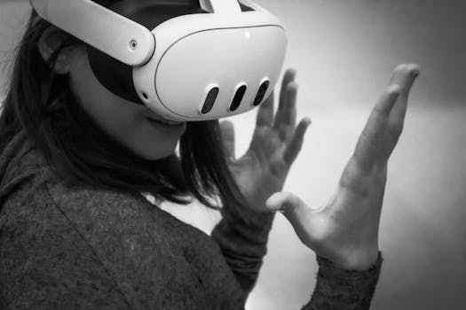 Black and white image of a woman wearing a VR headset, engaged in a virtual reality experience.