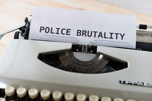 Close-up of a typewriter with the text 'POLICE BRUTALITY' on paper, highlighting the message of awareness.