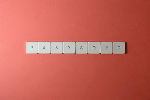 Focus on password security with white keyboard tiles spelling 'PASSWORD' on a coral background.