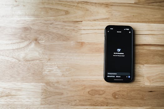 Mobile phone displaying AI chatbot interface on a wooden table