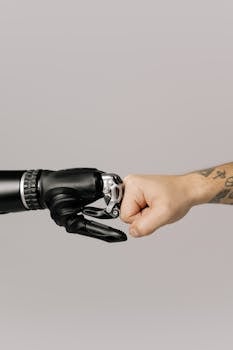 Close-up of a human fist bumping a prosthetic hand, symbolizing technology and human connection.