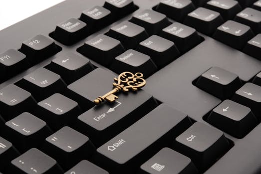 Close-up of an ornate vintage key placed on a modern computer keyboard.